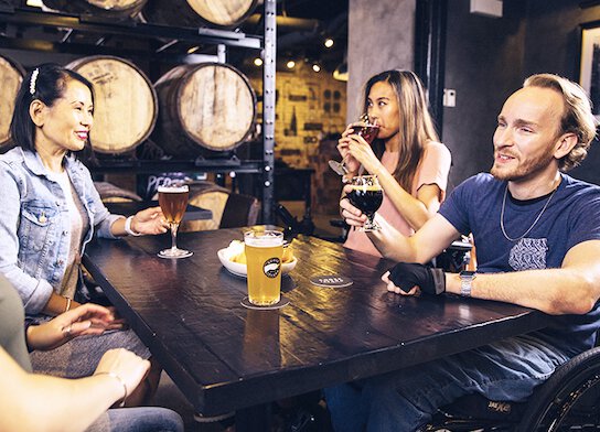 People trying beer at brewery tour experience.