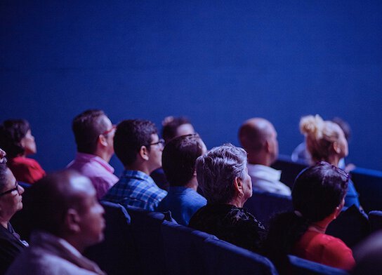 Audience at conference watching presentation.